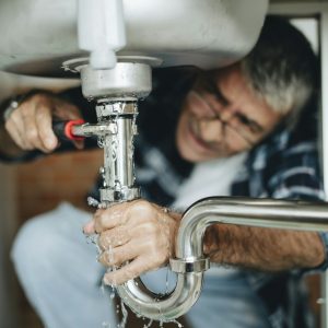 Plumber fixing the kitchen sink